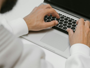 man typing on a laptop