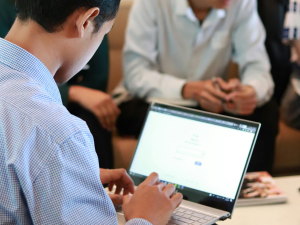 man typing on a computer during a business meeting